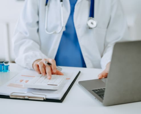 Doctor using calculator and notebook