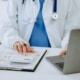 Doctor using calculator and notebook