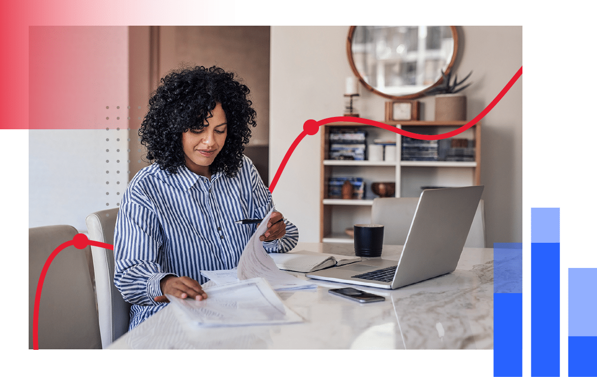 Woman reviewing paperwork in front of her laptop