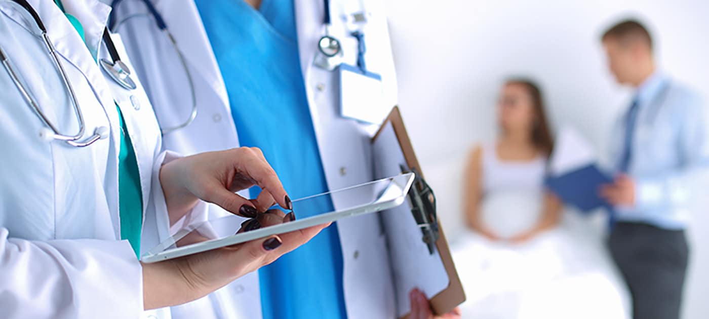 Doctors typing on a tablet