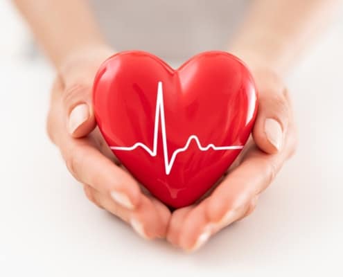 Woman holding red heart symbol