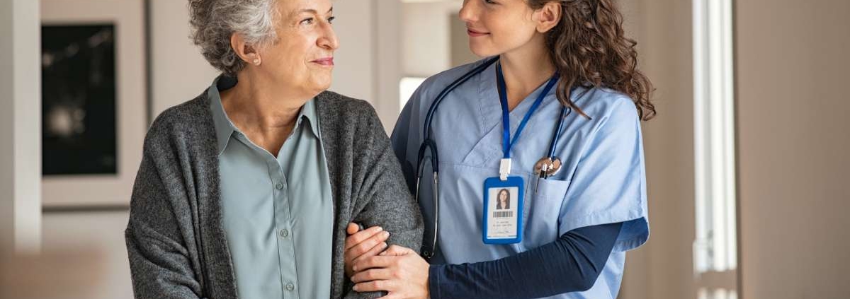 A nurse helping a senior patient walking
