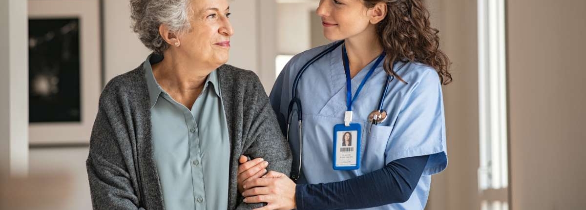 A nurse helping a senior patient walking