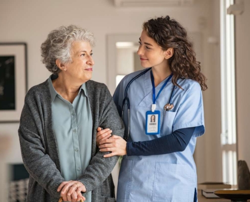 A nurse helping a senior patient walking