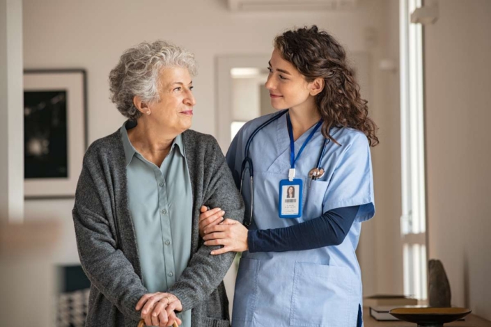 A nurse helping a senior patient walking