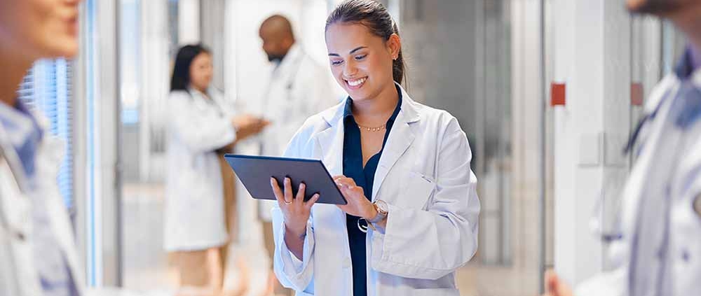 A member of a quality improvement team accesses data on a tablet while collaborating with the operations team