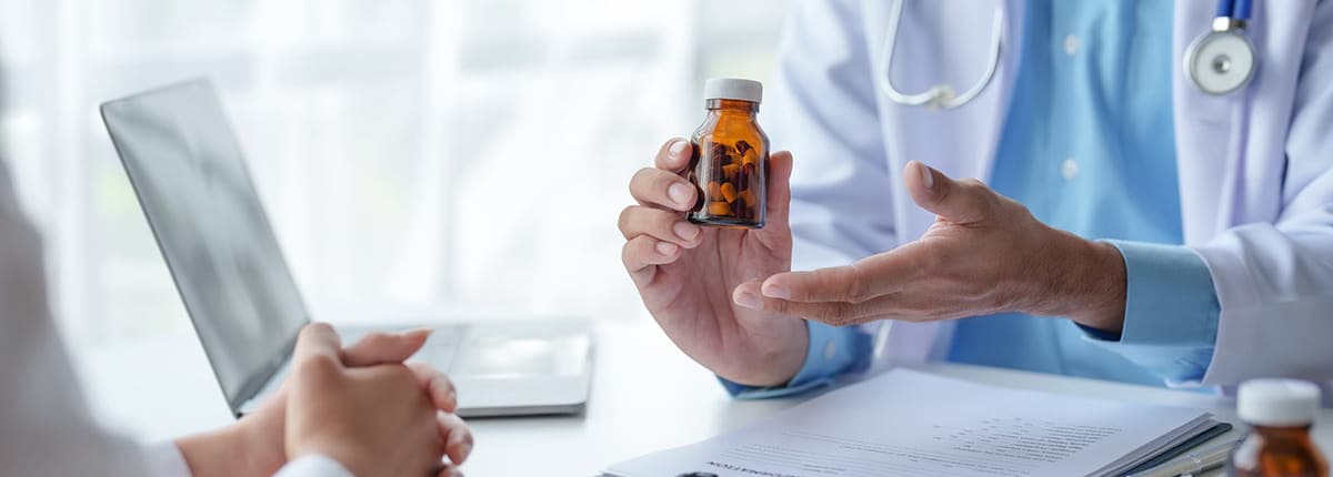 A doctor showing a medicine bottle to a patient