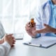 A doctor showing a medicine bottle to a patient