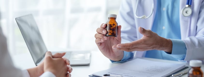 A doctor showing a medicine bottle to a patient