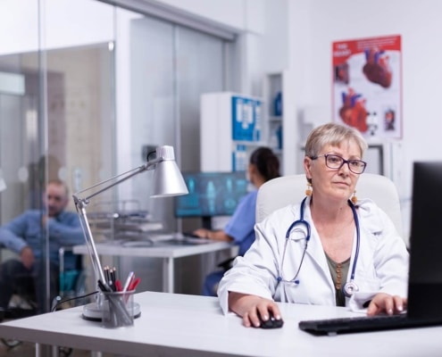 A frontline staff member enters patient safety data into a computer at a healthcare facility