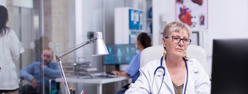 A frontline staff member enters patient safety data into a computer at a healthcare facility