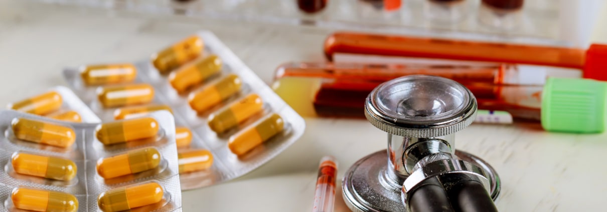 Health care with stethoscope and pills glass tube