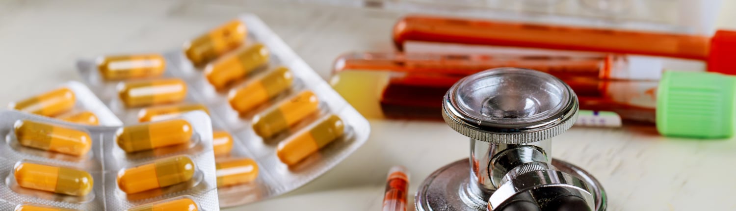 Health care with stethoscope and pills glass tube