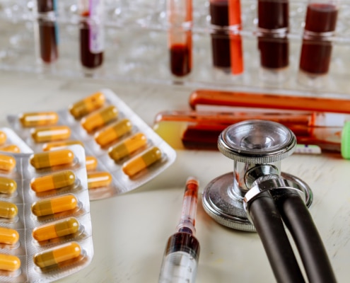 Health care with stethoscope and pills glass tube