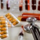 Health care with stethoscope and pills glass tube