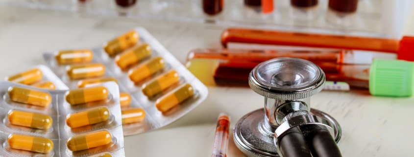 Health care with stethoscope and pills glass tube