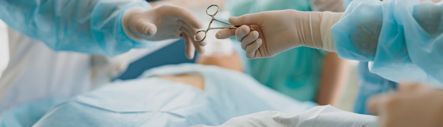 Assistant hands out instruments surgeon during surgery in the operating room