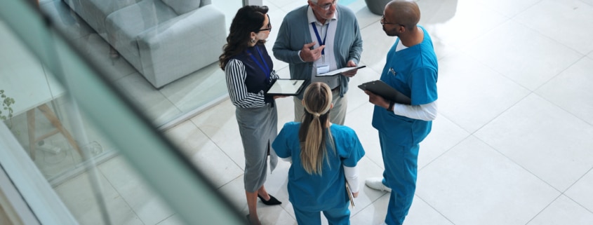 Doctors, medical team and tablet with discussion, advice and above for surgery or patient records.