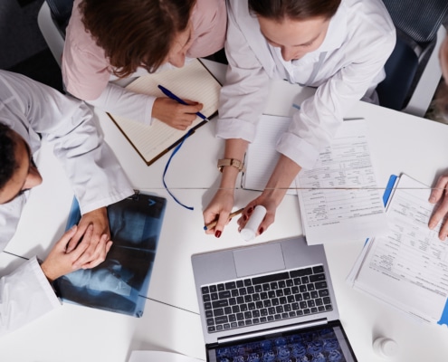 Group of young contemporary pharmacologists discussing new medicament