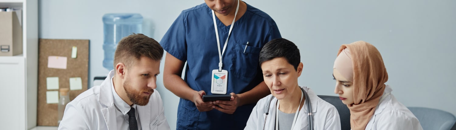 Team of doctors using a laptop to review grievance policy documents