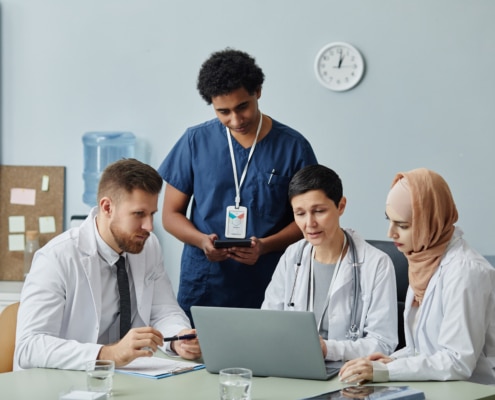 Team of doctors using a laptop to review grievance policy documents